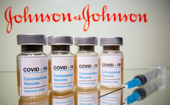 FILE PHOTO: Vials with a sticker reading, &quot;COVID-19 / Coronavirus vaccine / Injection only&quot; and a medical syringe are seen in front of a displayed Johnson & Johnson logo in this illustration taken October 31, 2020. REUTERS/Dado Ruvic/Illustration/File Photo